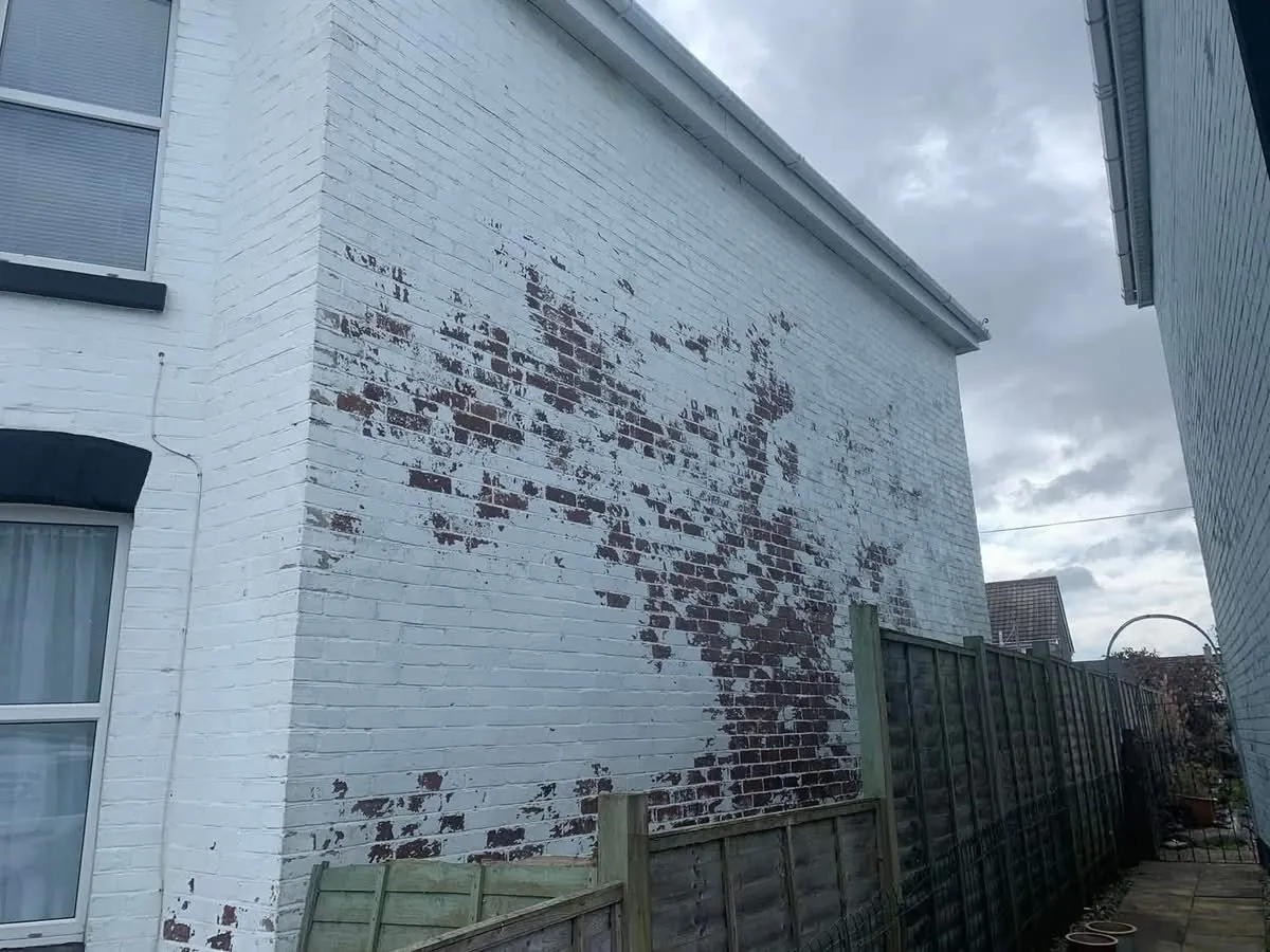 Peeling paint on a brick wall before redecoration in Callington